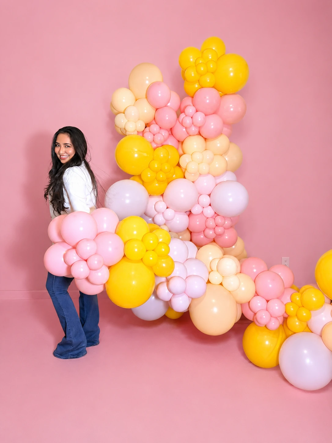 Ydnar Flores junto a una instalación colorida de globos de GoPhoenix